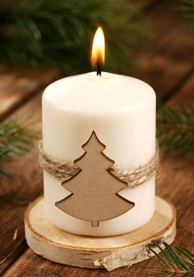 Christmas candle Candle with a Christmas tree on natural wood